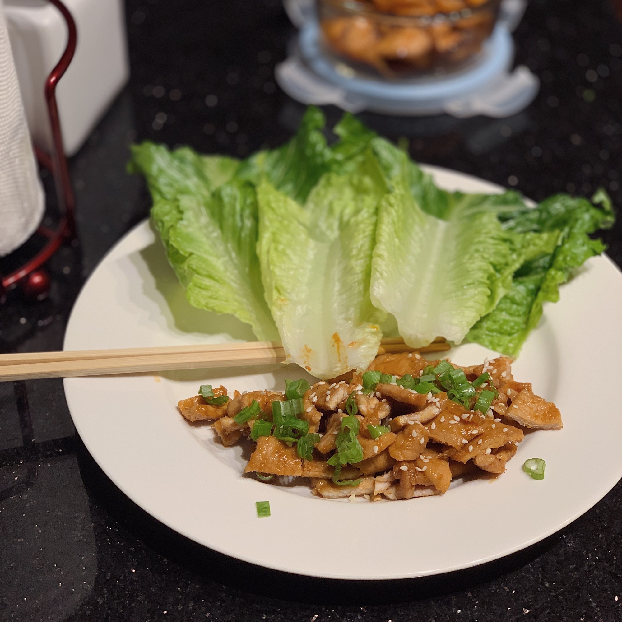 photo of Dwaeji Bulgogi on a plate with lettuce and chopsticks