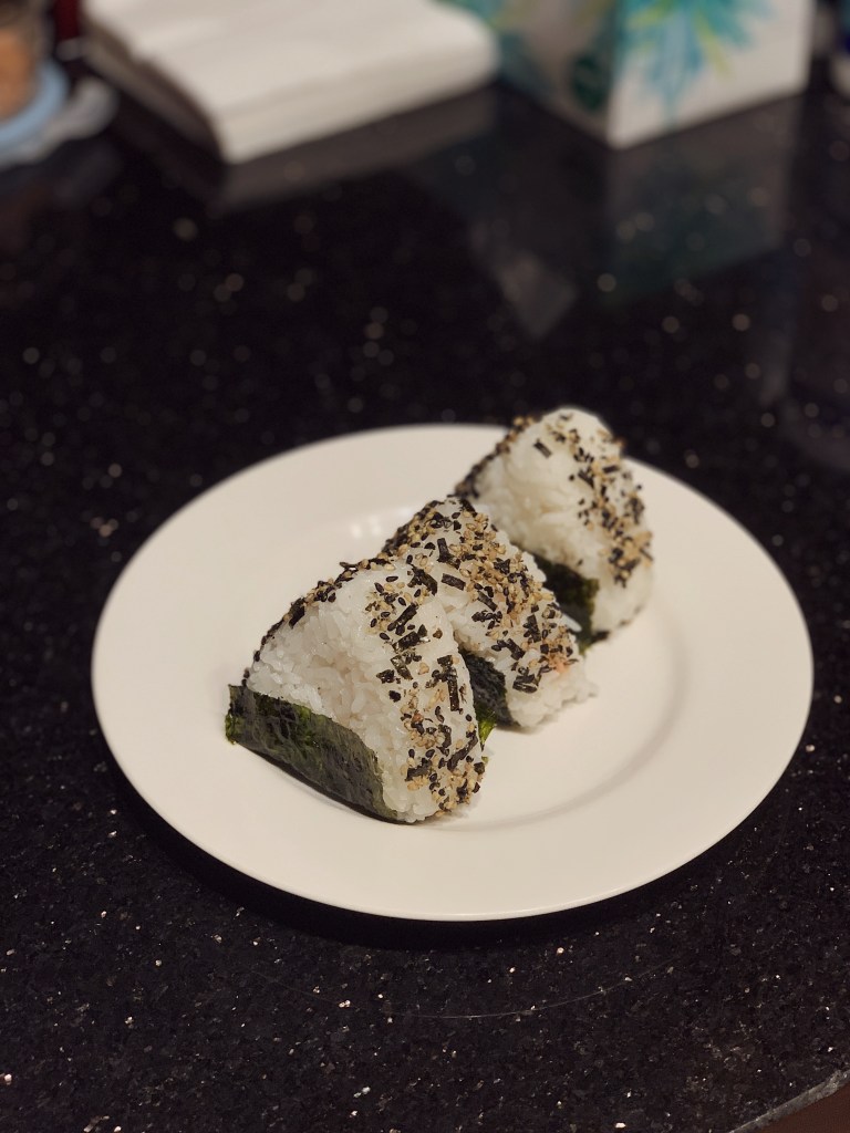 a plate with three rice onigiri