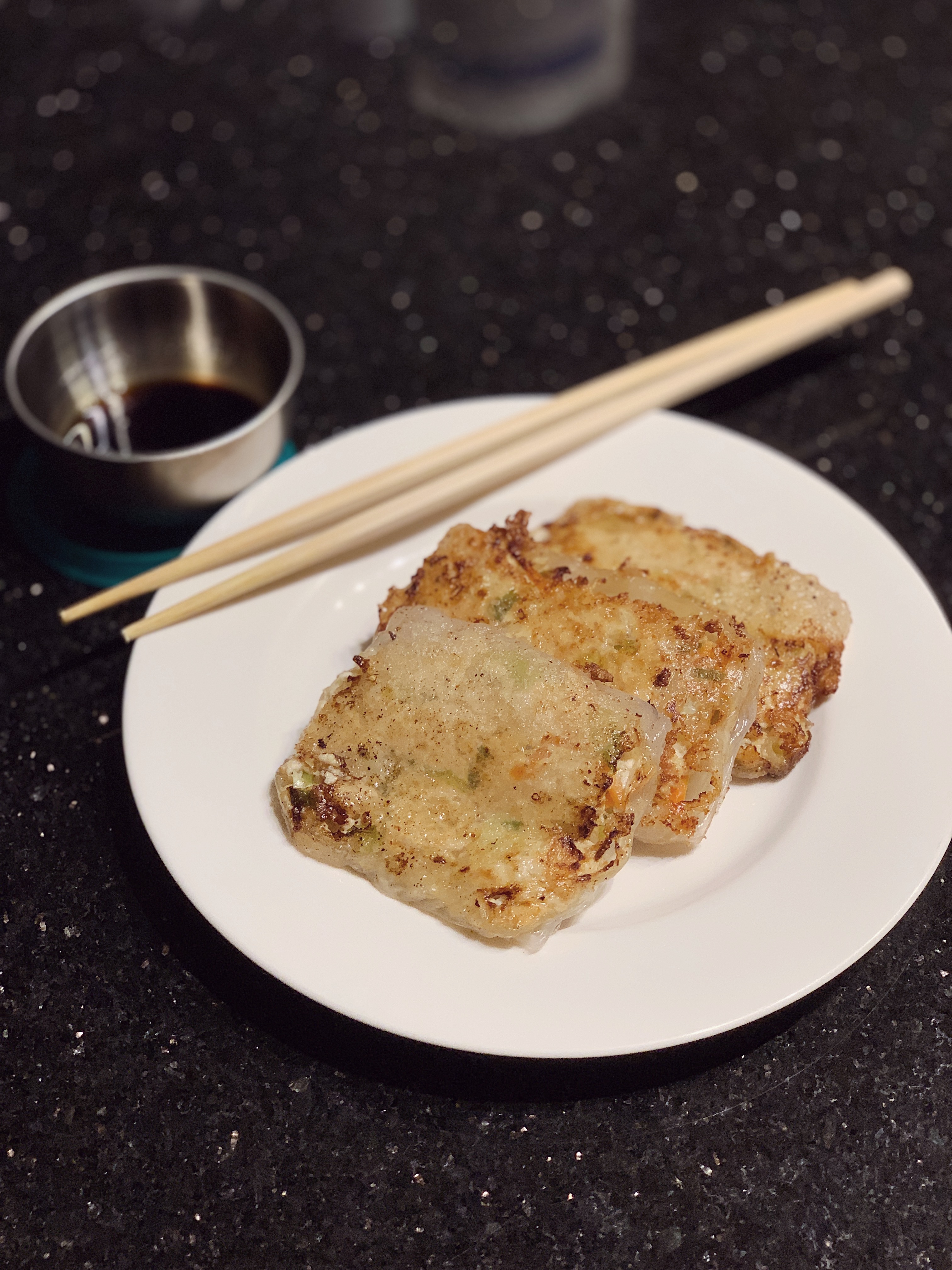 a plate with three tofu rice dumplings and chopsticks