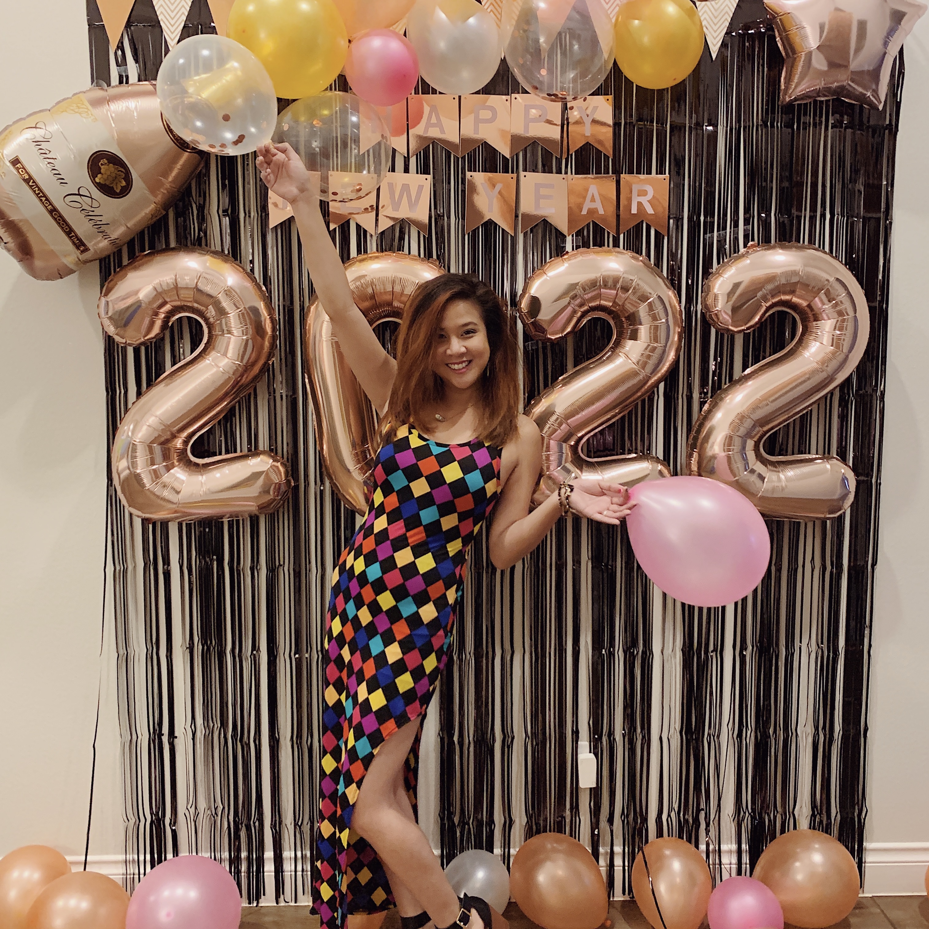 Siri Svay posing in front of decoration, holding balloons to celebrate the new year of 2022