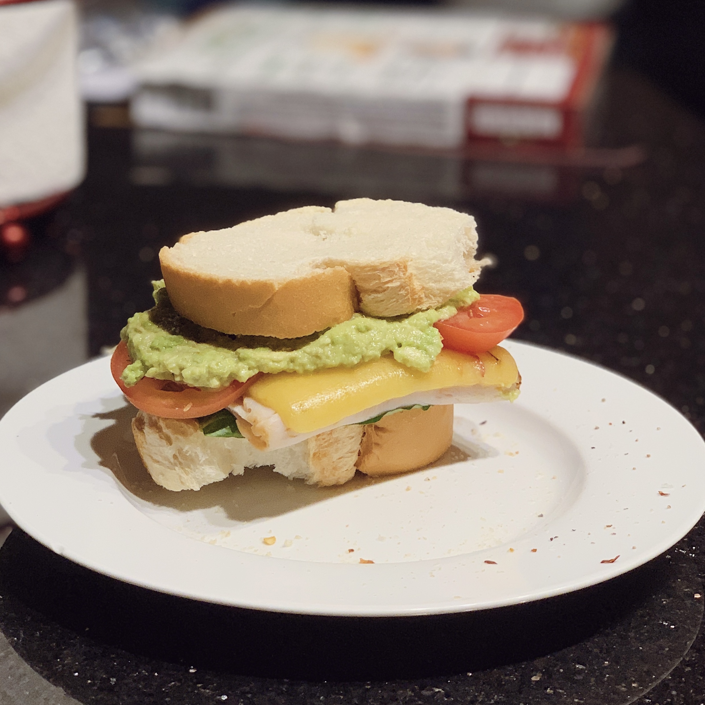 plate with an avocado turkey melt sandwich