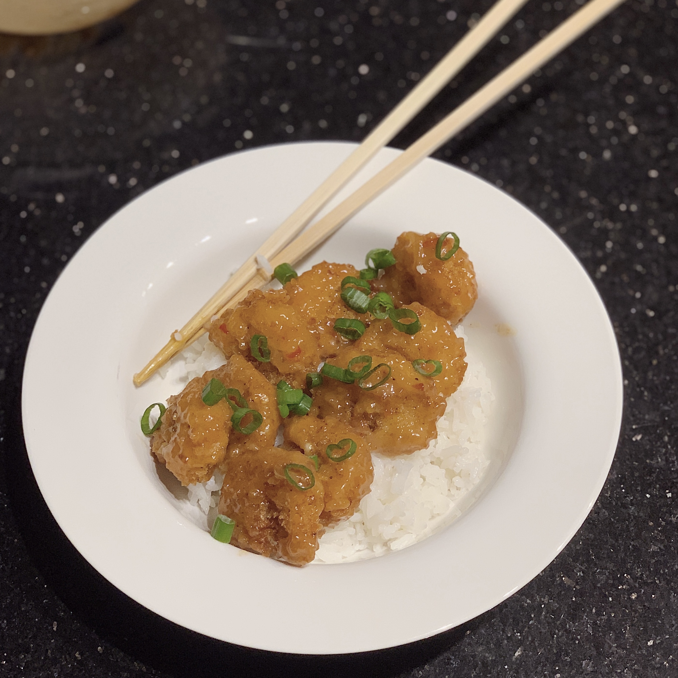 a bowl with chopsticks, fried bang bang shrimp and jasmine rice