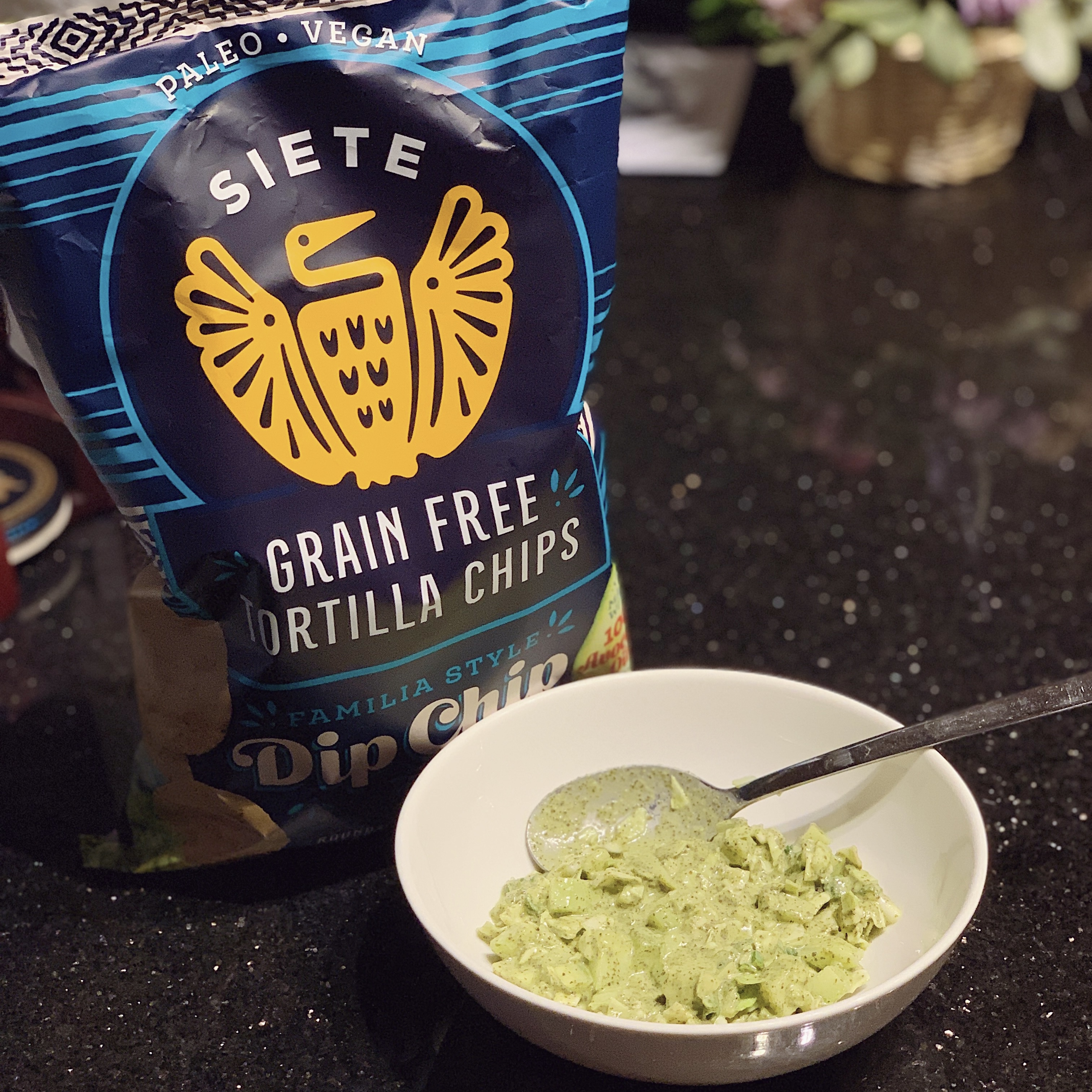 a bowl of green goddess dip and a bag with Siete dip chips