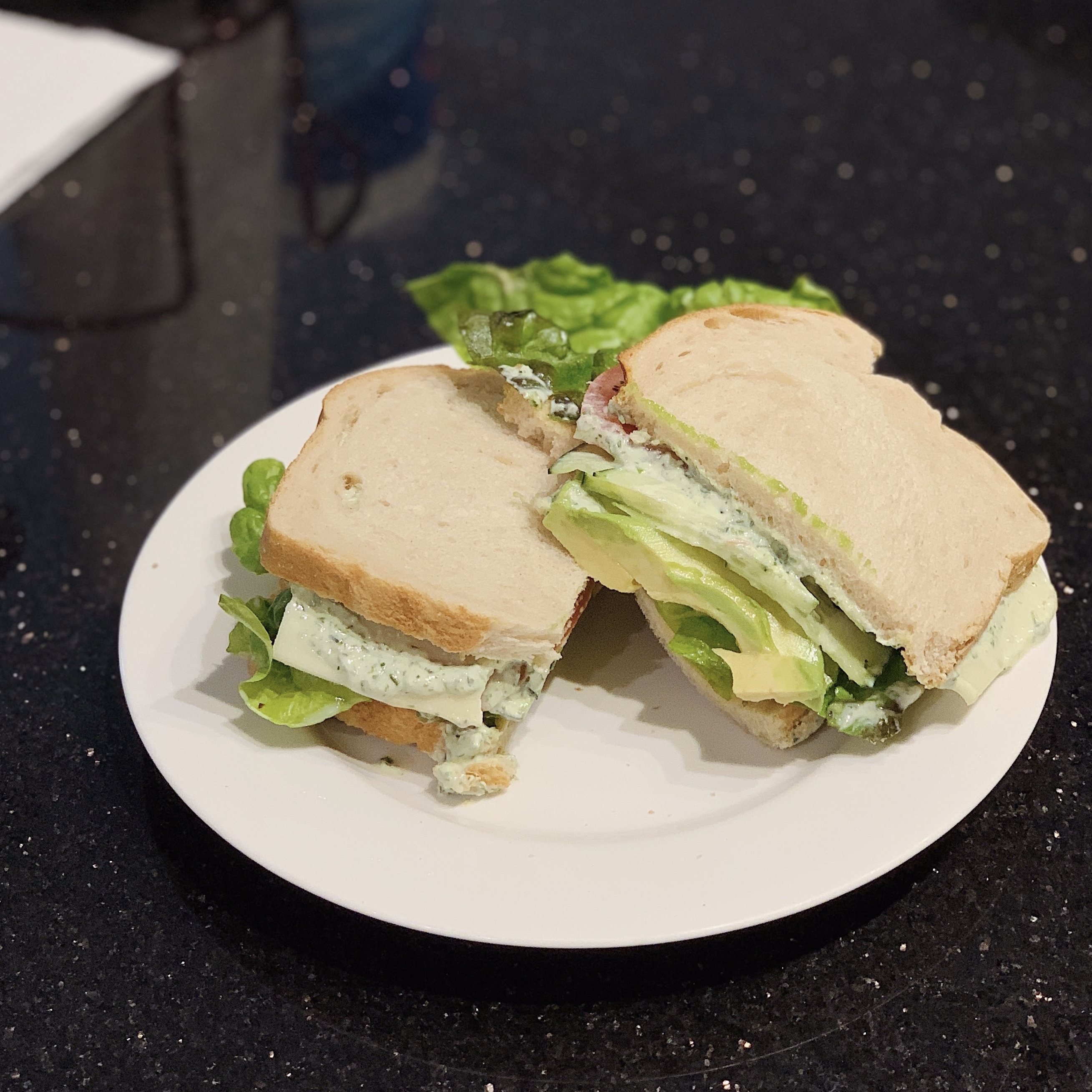 A plate of a sliced Green Goddess Sandwich.