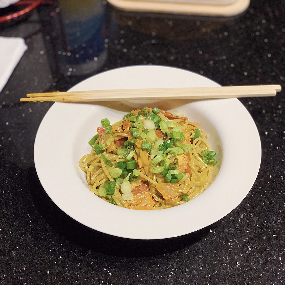 A bowl with chopsticks and Kimchi Pasta Carbonara.